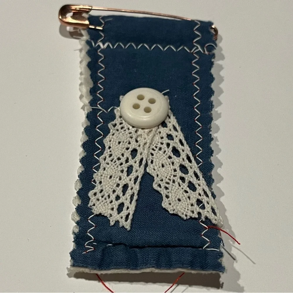 Navy quilted decorative patch.  The patch has a pin as closure.